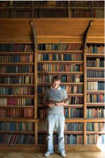 young man in front of library shelves